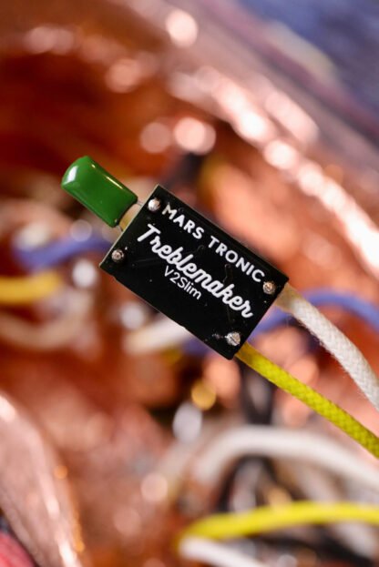 Rear view close-up of a prewired Slimline Treblemaker close-up, showing the logo. It’s suspended above intricate guitar electronics, highlighting Mars-Tronic’s precision craftsmanship